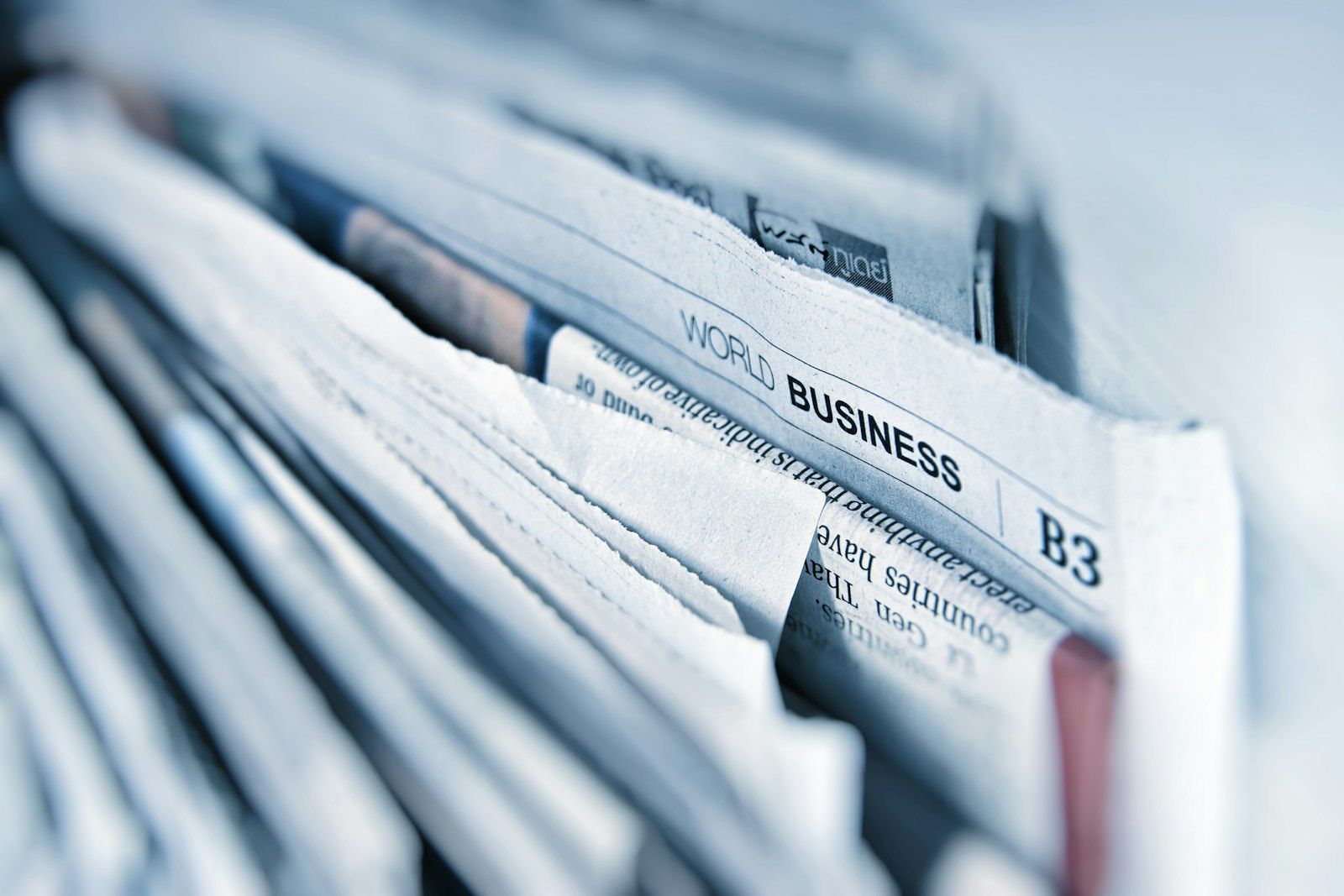 Stack of newspapers showing world business section